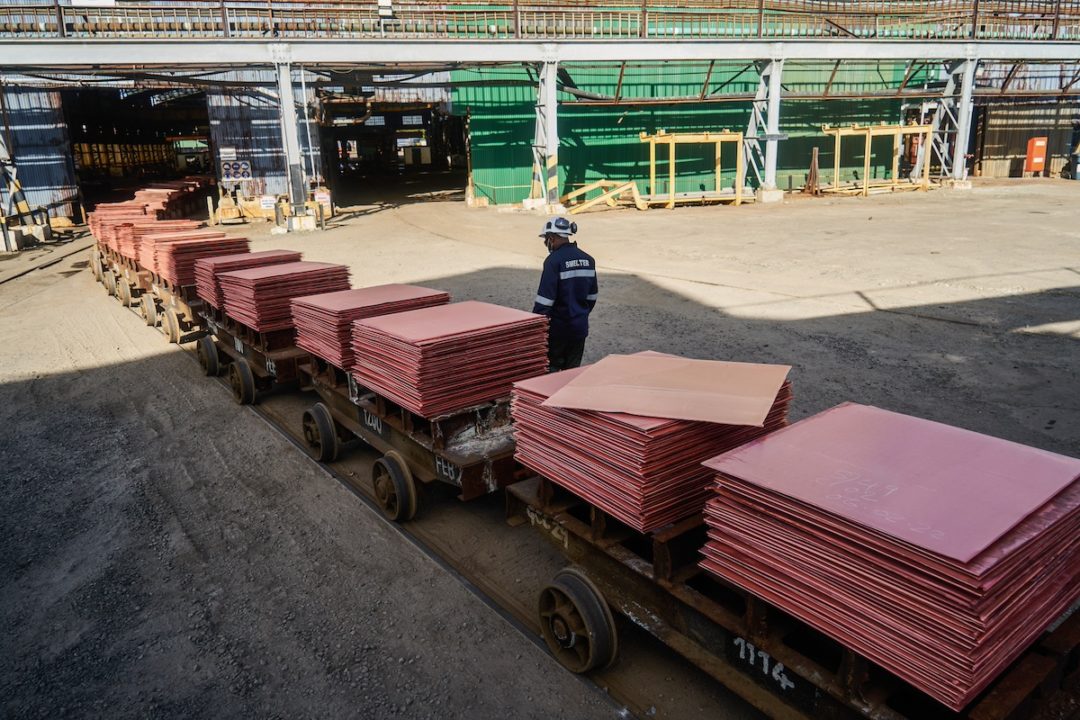 Stacks of square red sheets in multiple small rail cars