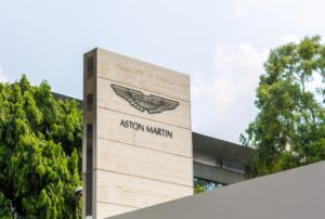 A grey cement building, with "Aston Martin" written on the exterior