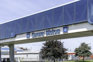 A skybridge with large blue windows, with "General Motors" written on the bottom in blue lettering