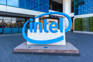 A LARGE INTEL CORP SIGN CAN BE SEEN IN FRONT OF A GLASS AND CONCRETE BUILDING.