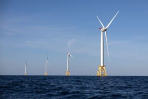 FOUR WIND TURBINES AT SEA.