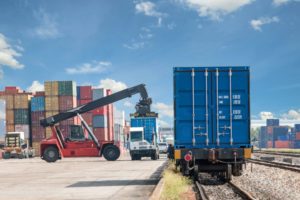 Forklift handling container box loading to freight train