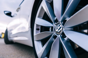 CLOSE-UP OF A TIRE ON A VOLKSWAGEN CAR. THE VW LOGO CAN BE SEEN IN THE MIDDLE OF THE TIRE.